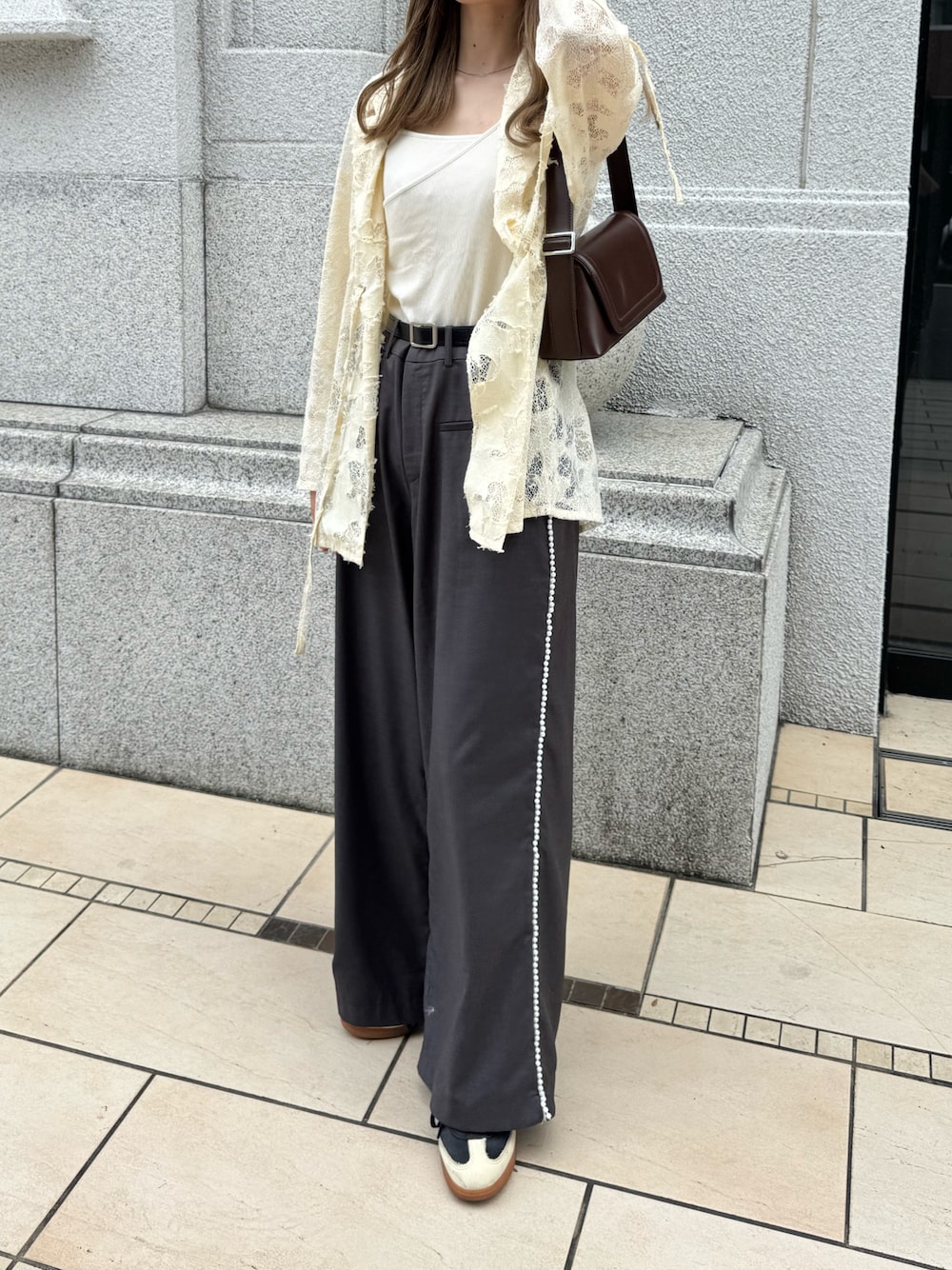 ホワイト系のテーラードジャケット、ブラウン系のショルダーバッグ、グレー系のスラックスを着用したレディースの秋コーディネートの1枚目の写真