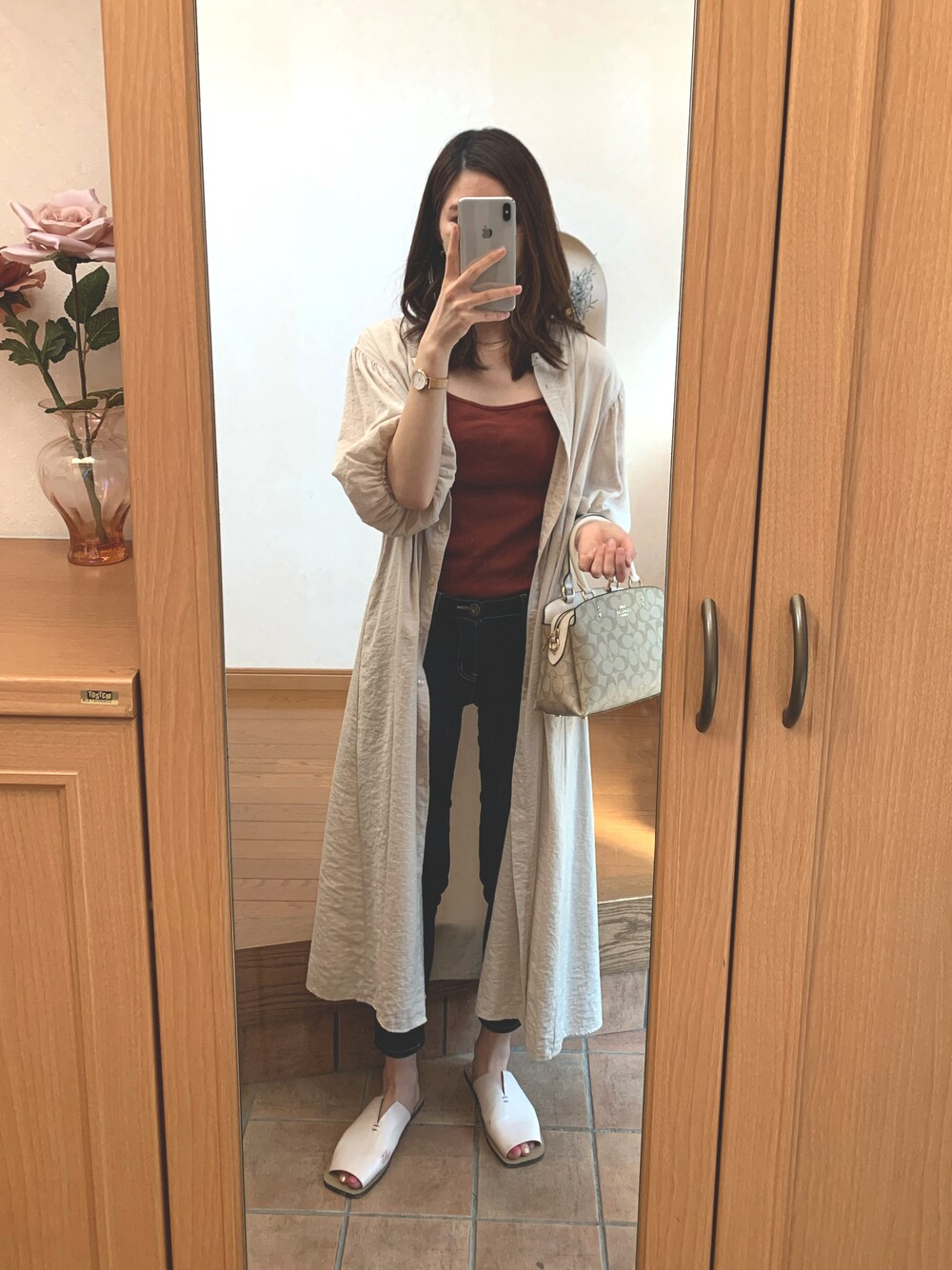 ブラウン系のタンクトップ、ベージュ系のハンドバッグ、ホワイト系のワンピースを着用したレディースの夏コーディネートの1枚目の写真