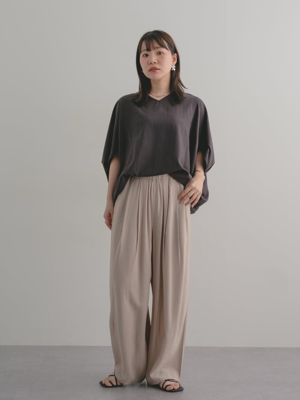 ベージュ系のパンツ、ブラウン系のシャツ/ブラウスを着用したレディースの春コーディネートの1枚目の写真