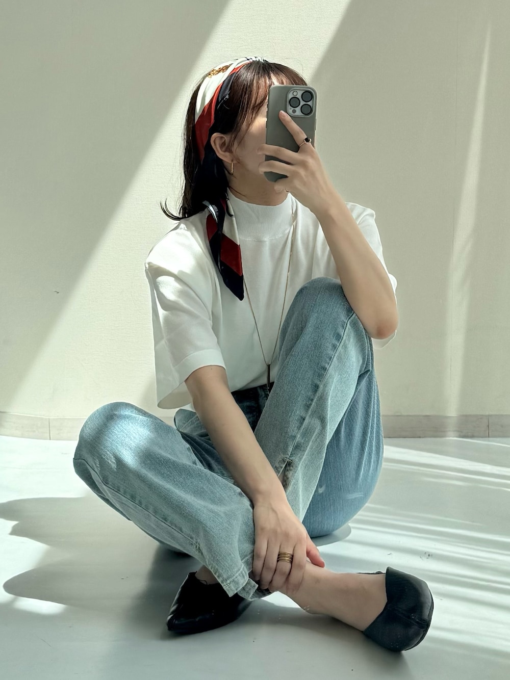 ブルー系のデニムパンツ、ホワイト系のニット/セーター、ブルー系のデニムパンツを着用したレディースの春コーディネートの1枚目の写真