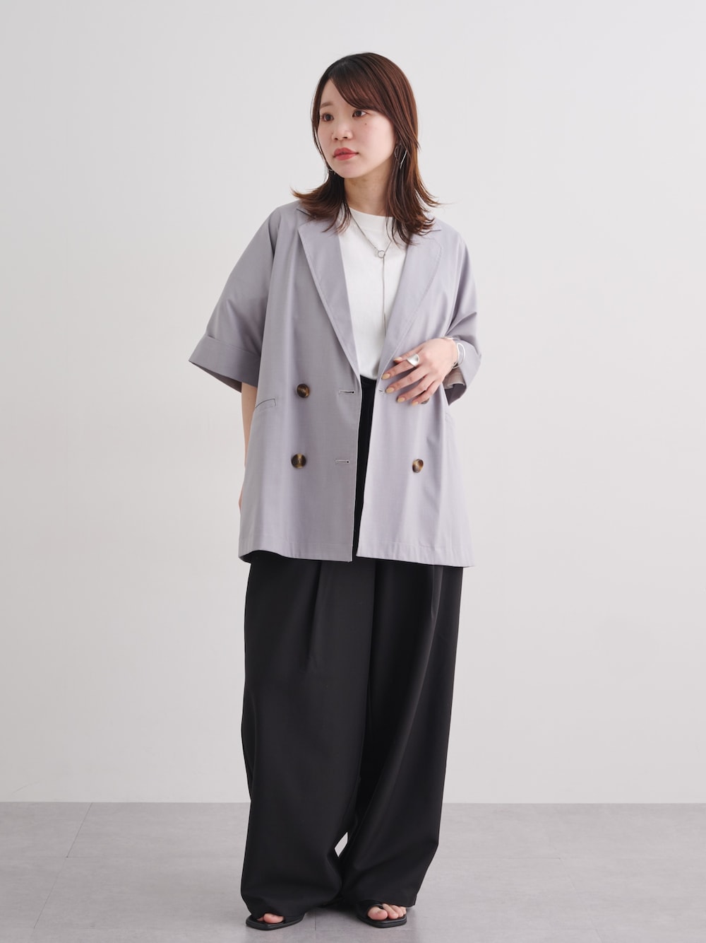 ホワイト系のTシャツ/カットソー、ブラック系のスラックス、ブラック系のスラックスを着用したレディースの春コーディネートの1枚目の写真