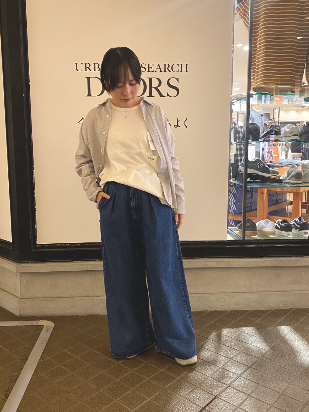 ブルー系のデニムパンツ、ホワイト系のTシャツ/カットソー、グレー系のシャツ/ブラウスを着用したレディースの秋コーディネートの1枚目の写真