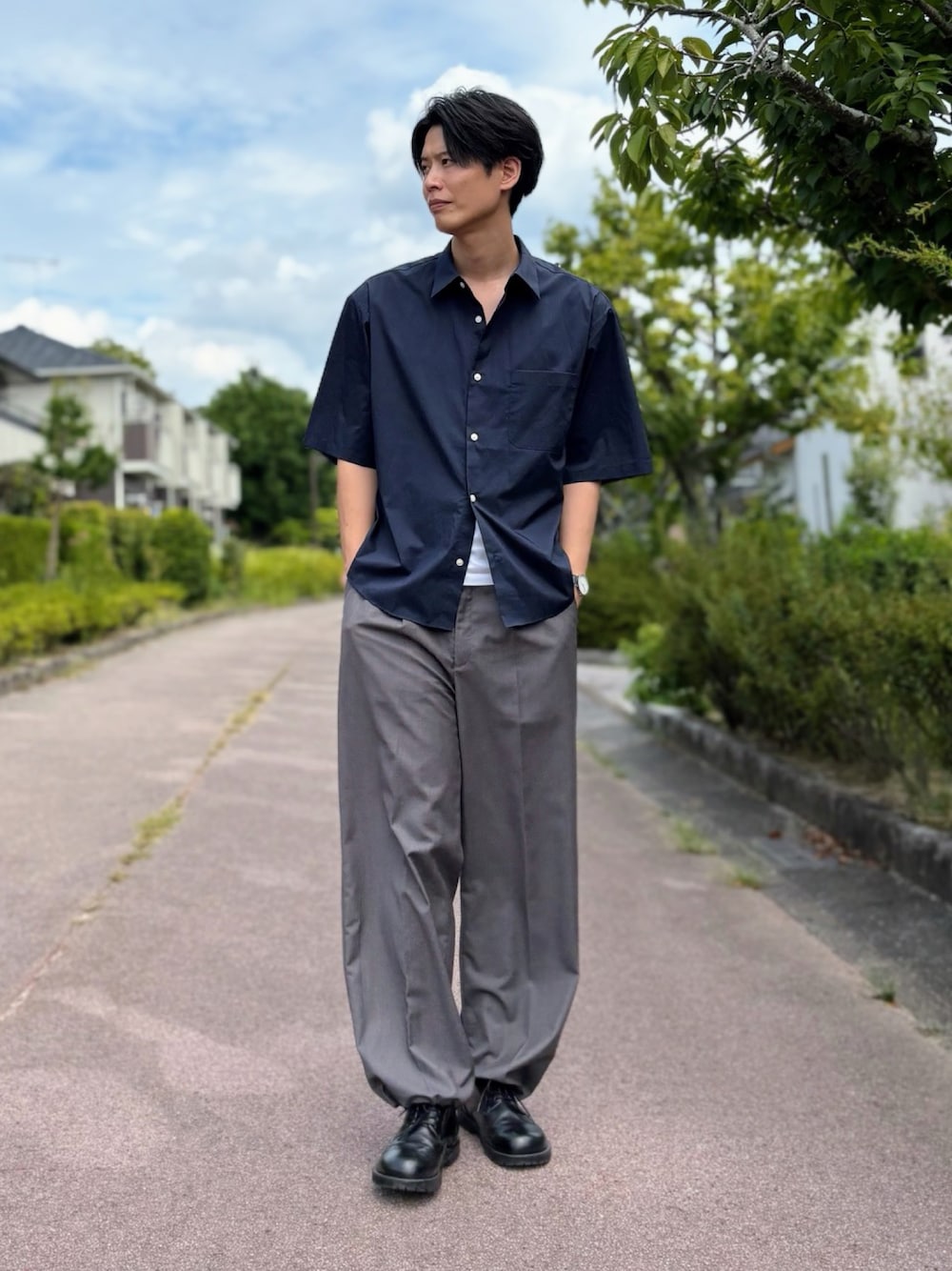 グレー系のスラックス、ブラック系のドレスシューズ、ブルー系のシャツ/ブラウスを着用したメンズの夏コーディネートの1枚目の写真