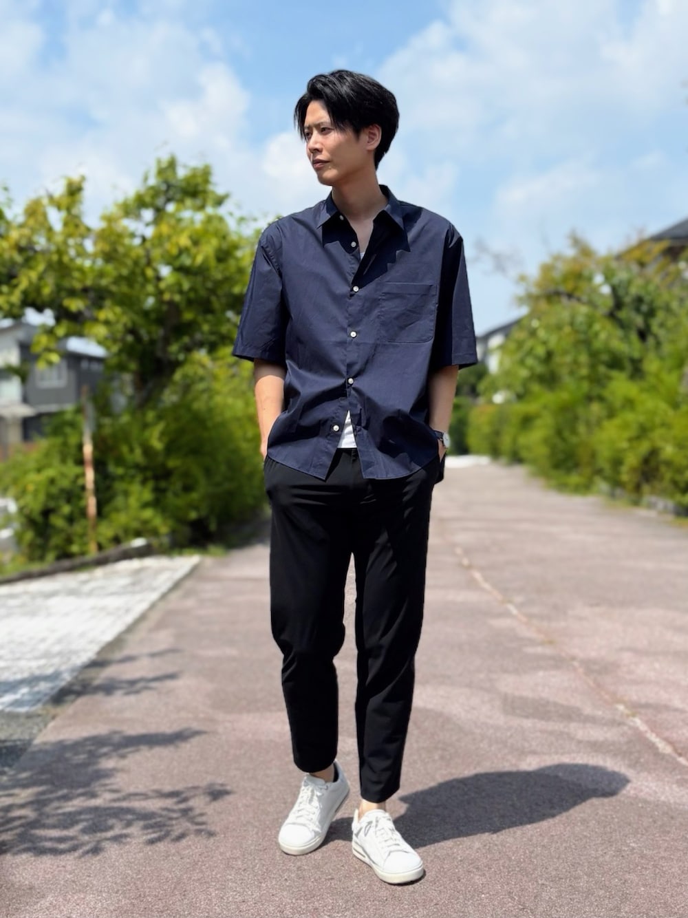 ホワイト系のスニーカー、ブラック系のスラックス、ブルー系のシャツ/ブラウスを着用したメンズの夏コーディネートの1枚目の写真