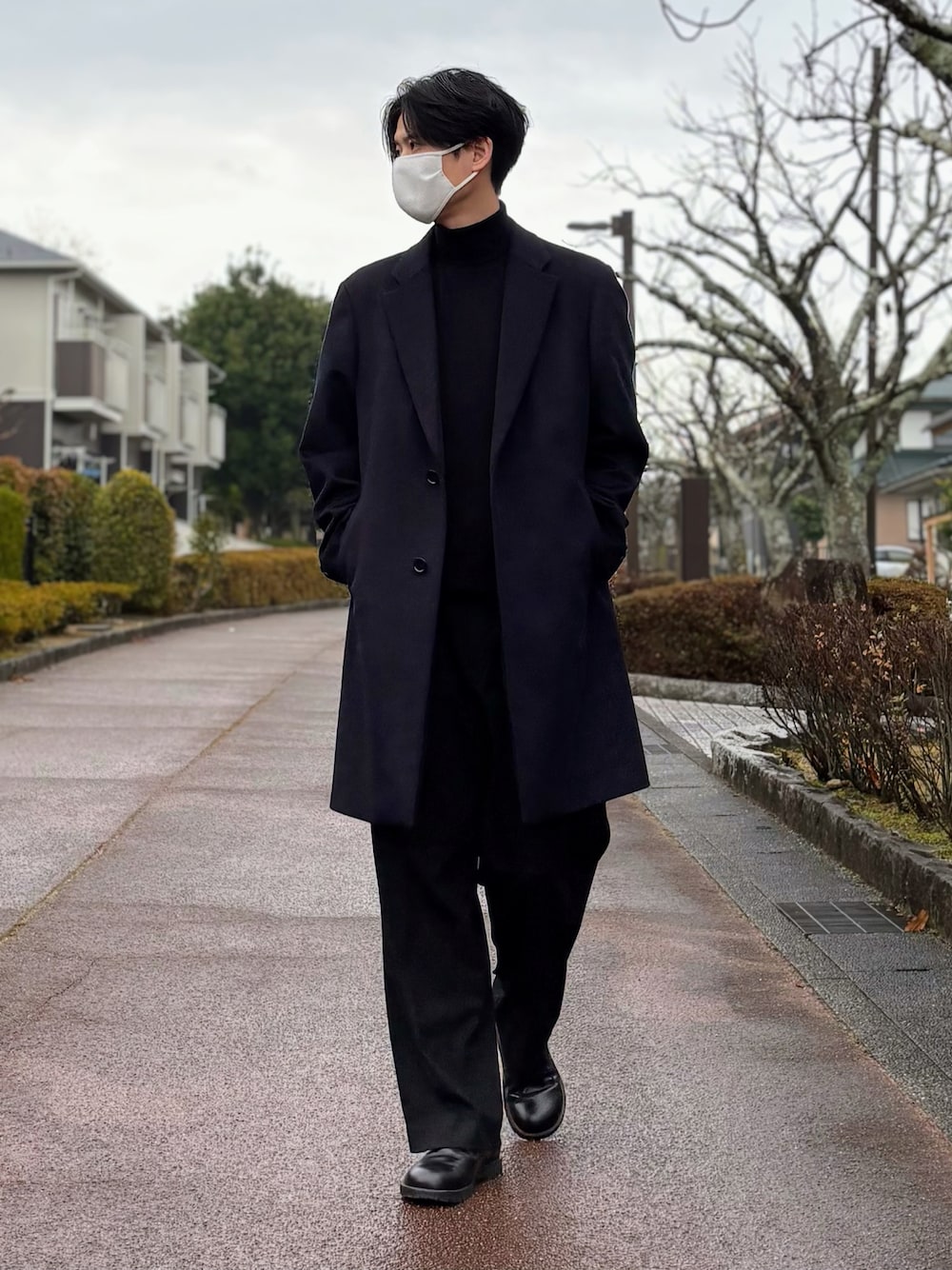 ブルー系のチェスターコート、ブラック系のスラックス、ブラック系のドレスシューズを着用したメンズの冬コーディネートの1枚目の写真