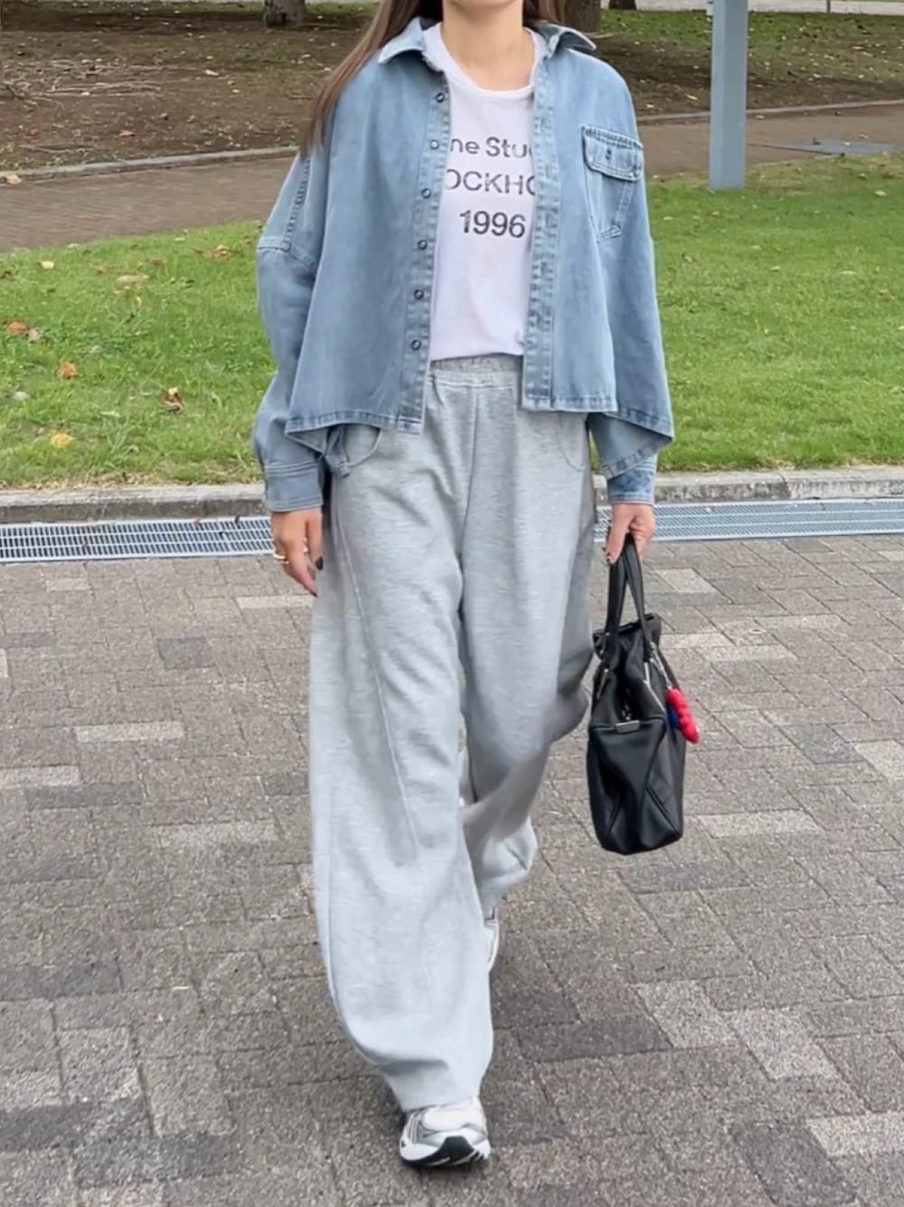 ブルー系のシャツ/ブラウス、グレー系のスウェットパンツ、ホワイト系のスニーカーを着用したレディースの秋コーディネートの1枚目の写真