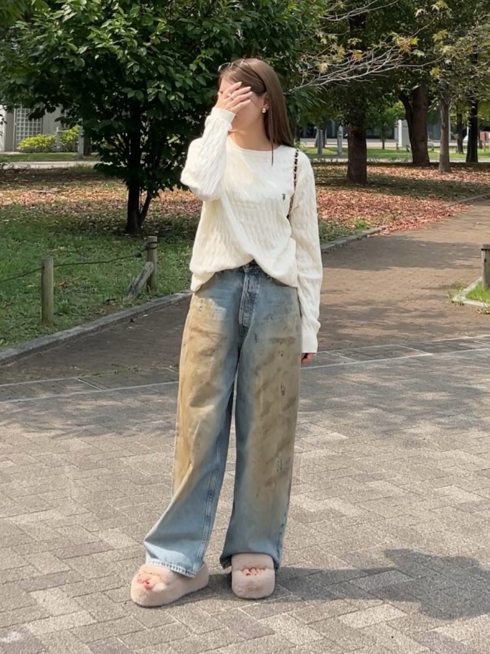 ホワイト系のニット/セーター、ブルー系のデニムパンツ、ベージュ系のサンダルを着用したレディースの秋コーディネートの1枚目の写真