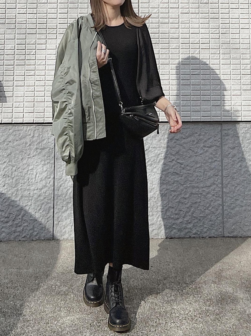 ブラック系のワンピース、グリーン系のMA-1、ブラック系のブーツを着用したレディースの冬コーディネートの1枚目の写真