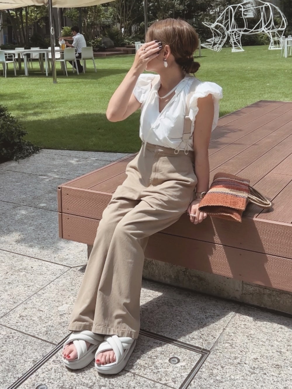 ホワイト系のシャツ/ブラウス、ベージュ系のその他パンツ、ブラウン系のバッグを着用したレディースの夏コーディネートの1枚目の写真