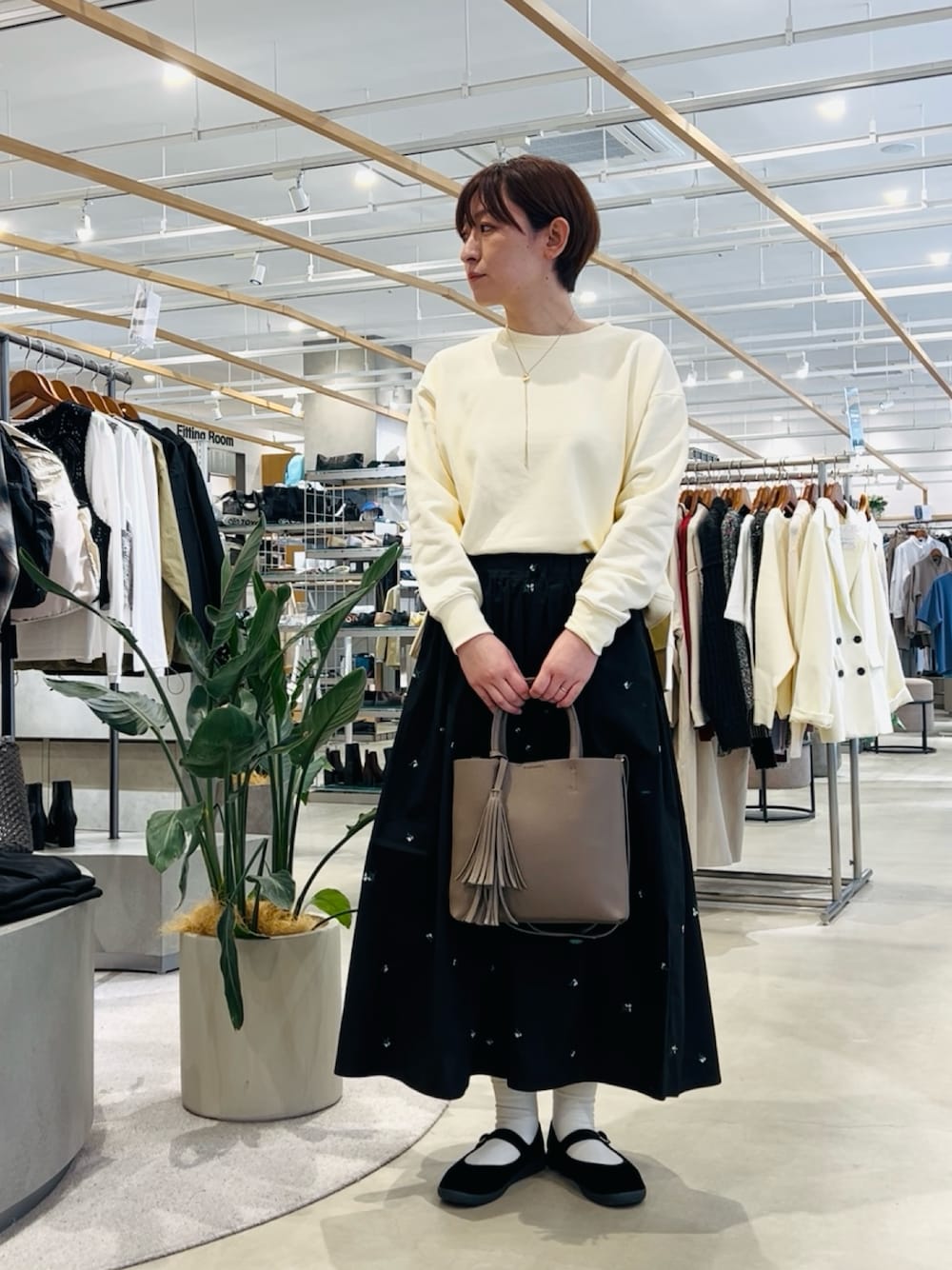 ホワイト系のTシャツ/カットソー、グレー系のトートバッグ、ブラック系のスカートを着用したレディースの春コーディネートの1枚目の写真