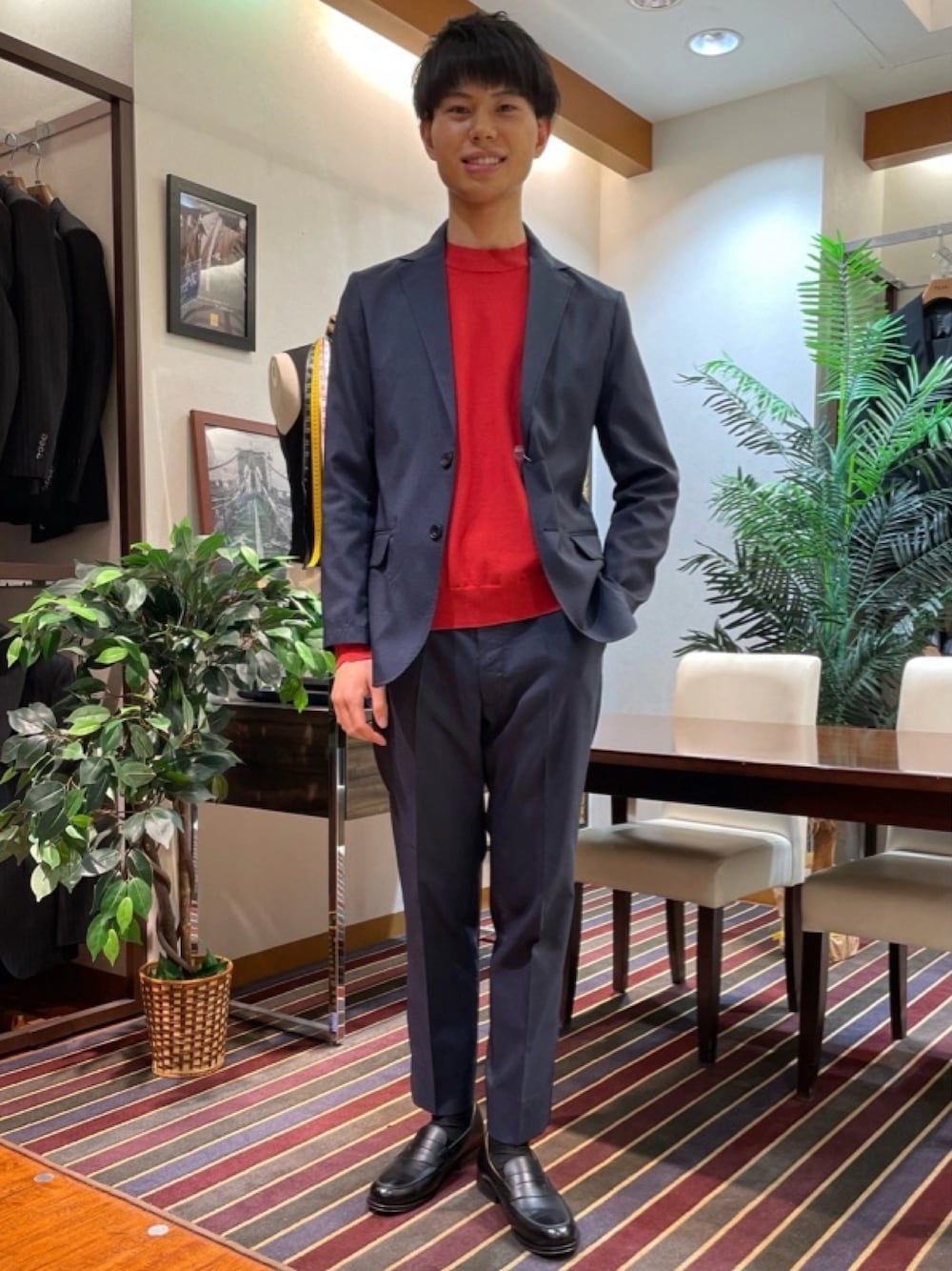ブルー系のテーラードジャケット、レッド系のニット/セーター、ブルー系のスラックスを着用したメンズの春コーディネートの1枚目の写真