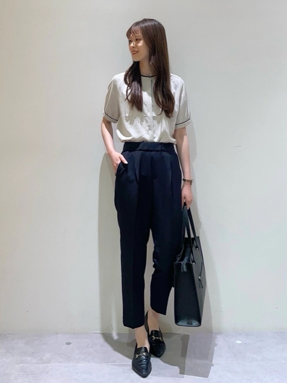 ベージュ系のシャツ/ブラウス、ブルー系のスラックス、ブラック系のトートバッグを着用したレディースの夏コーディネートの1枚目の写真