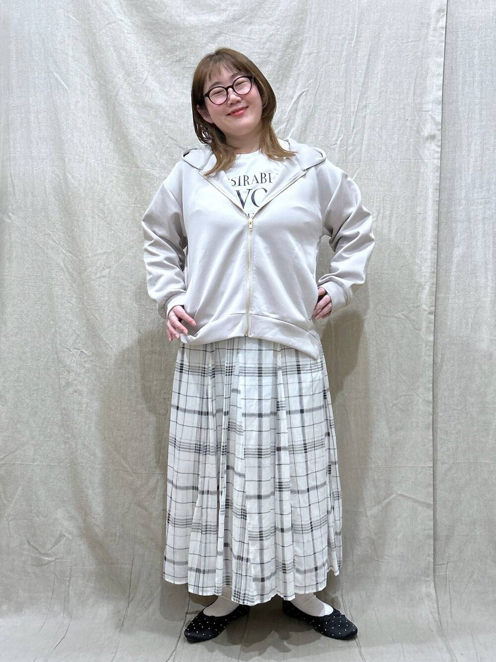 ベージュ系のスカート、ホワイト系のTシャツ/カットソー、ベージュ系のパーカーを着用したレディースの冬コーディネートの1枚目の写真