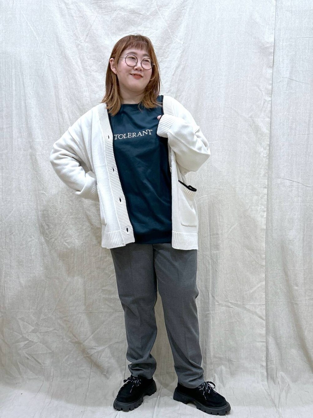 グレー系のその他パンツ、グリーン系のTシャツ/カットソー、ホワイト系のカーディガン/ボレロを着用したレディースの秋コーディネートの1枚目の写真