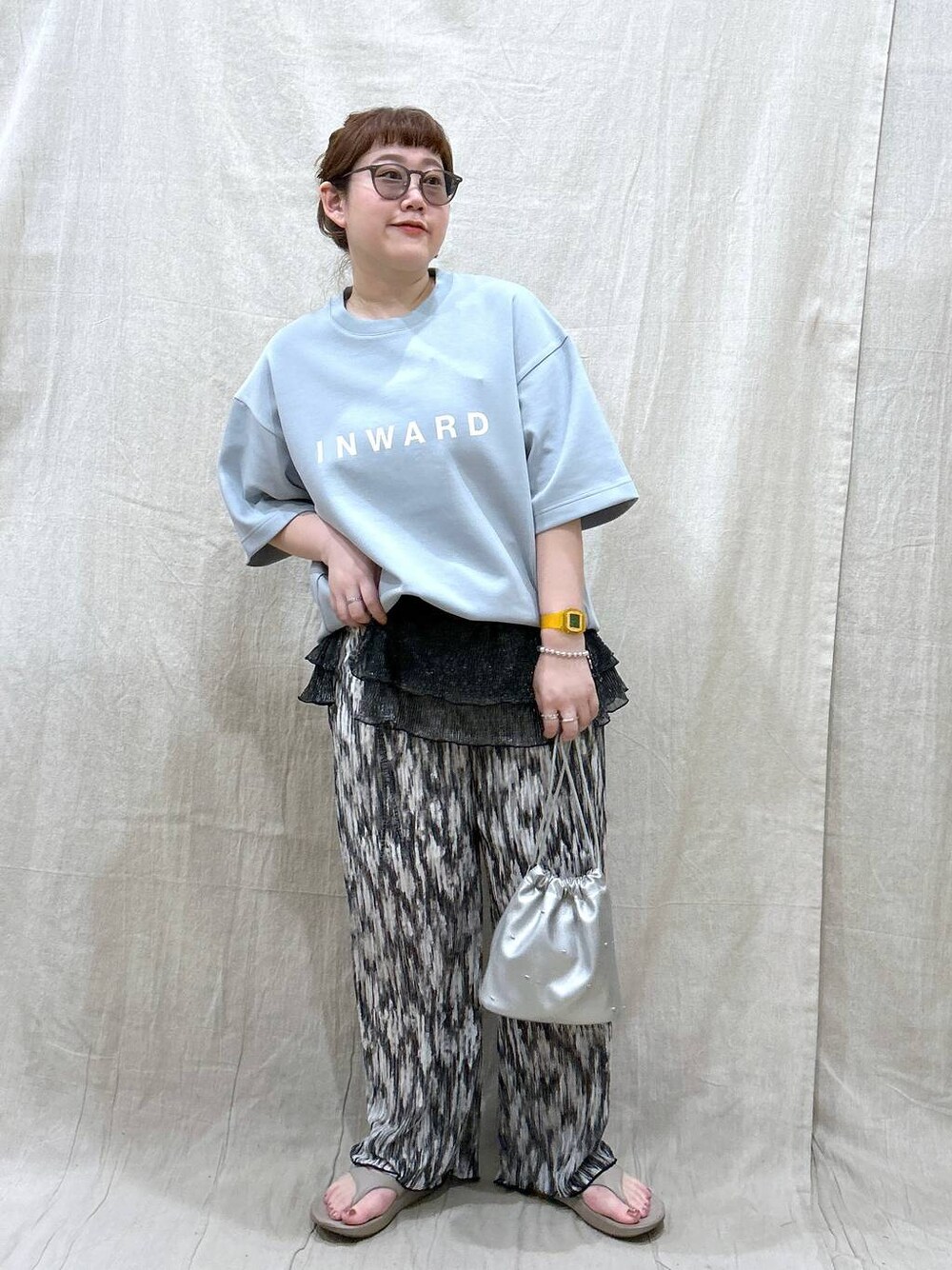 ホワイト系のショルダーバッグ、ベージュ系のサンダル、グリーン系のTシャツ/カットソーを着用したレディースの夏コーディネートの1枚目の写真