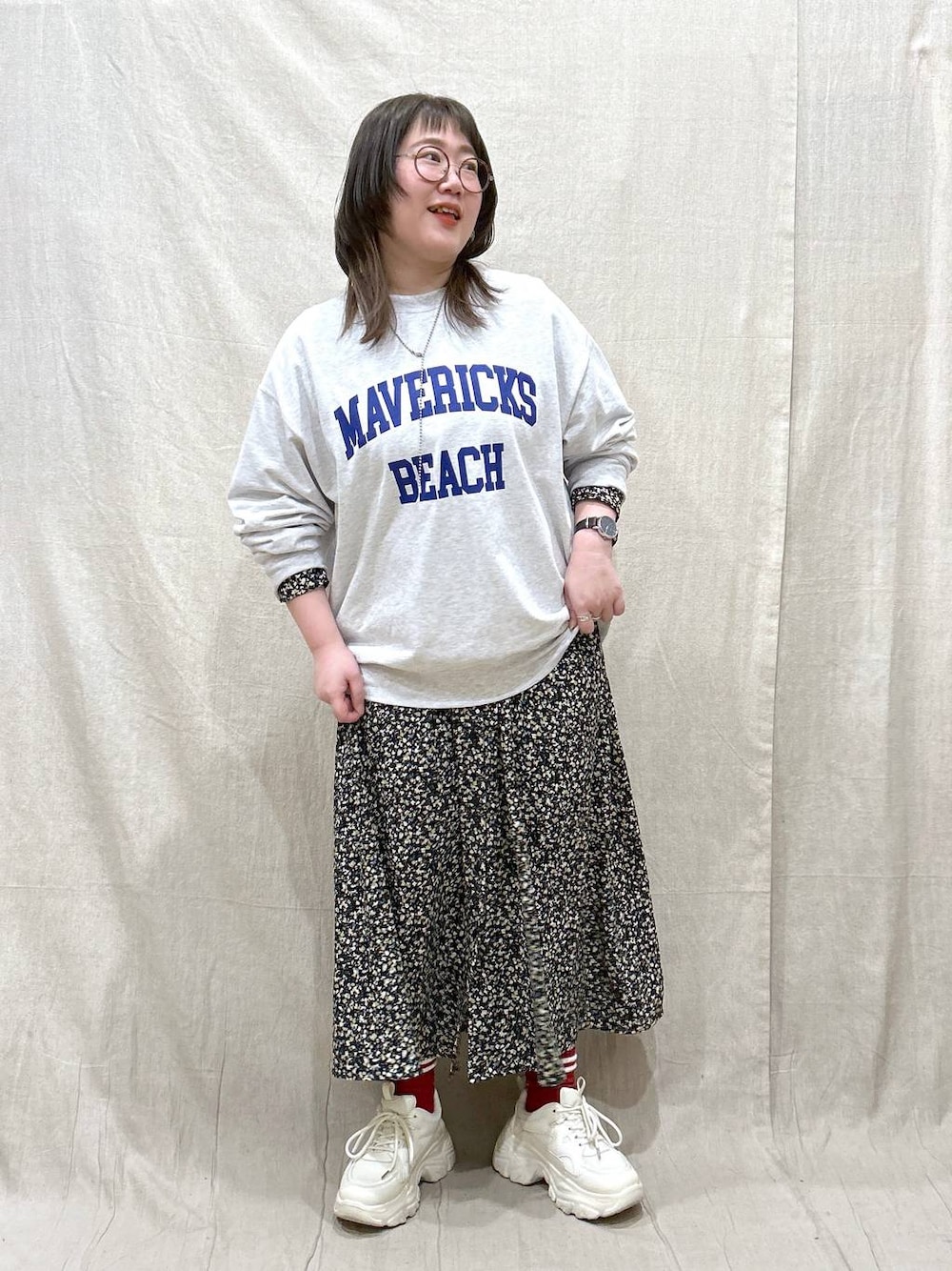 グレー系のスウェット、ホワイト系のスニーカー、ブラック系のワンピースを着用したレディースの春コーディネートの1枚目の写真
