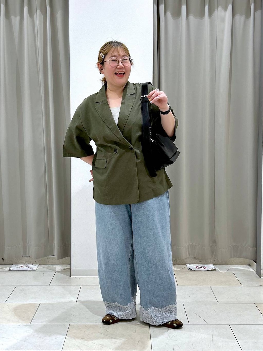 ブルー系のデニムパンツ、ブラック系のショルダーバッグ、ブラウン系のバレエシューズを着用したレディースの夏コーディネートの1枚目の写真