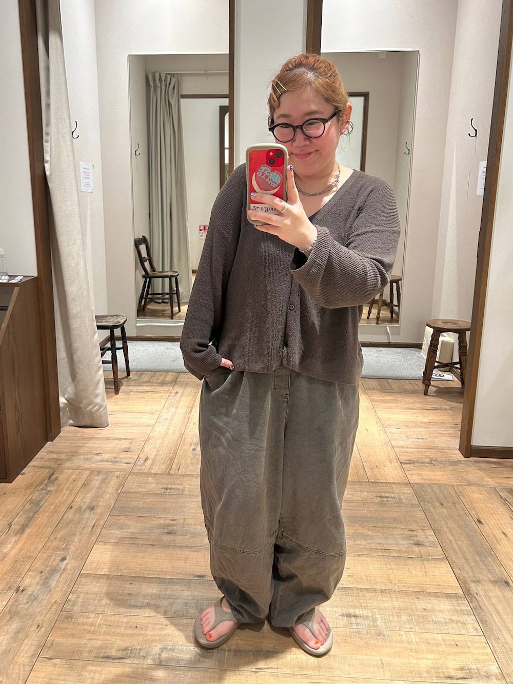 ブラウン系のデニムパンツ、ホワイト系のキャミソール、ベージュ系のサンダルを着用したレディースの秋コーディネートの1枚目の写真