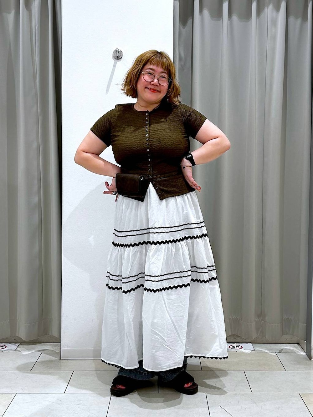 ブルー系のデニムパンツ、ブラウン系のボディバッグ/ウエストポーチ、ブラウン系のTシャツ/カットソーを着用したレディースの夏コーディネートの1枚目の写真