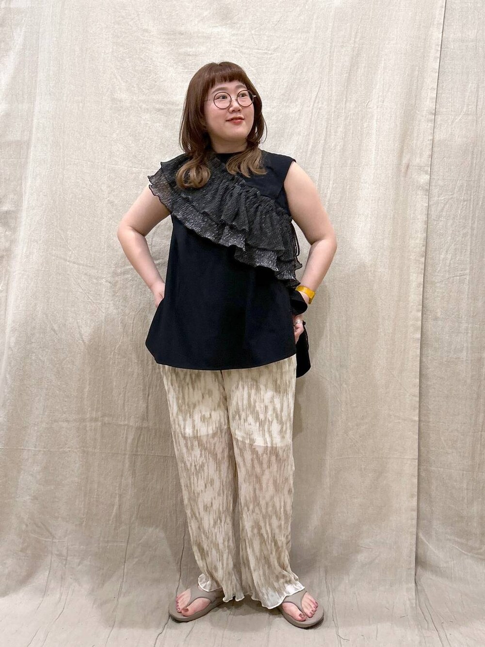 ベージュ系のその他パンツ、ベージュ系のサンダル、ブラック系のTシャツ/カットソーを着用したレディースの夏コーディネートの1枚目の写真