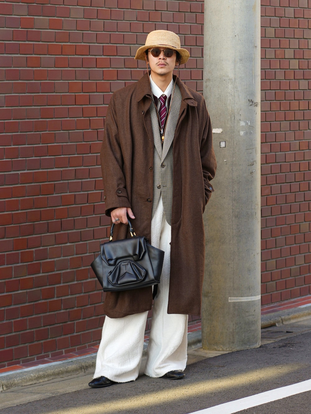 ブラック系のハンドバッグ、ホワイト系のその他パンツ、ブラック系のドレスシューズを着用したメンズの秋コーディネートの1枚目の写真