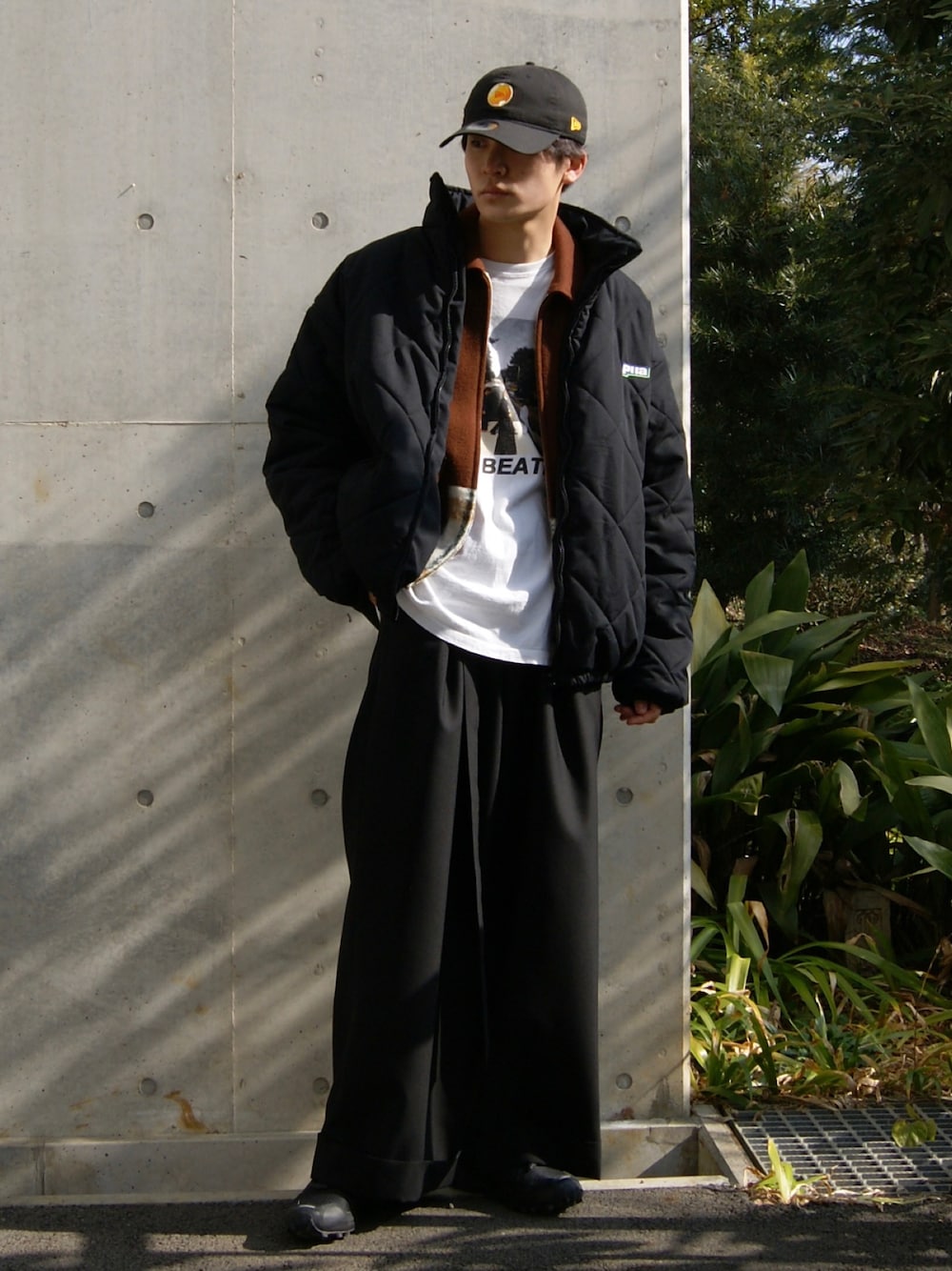ブラック系のその他パンツ、ブラック系のスニーカー、ホワイト系のTシャツ/カットソーを着用したメンズの冬コーディネートの1枚目の写真