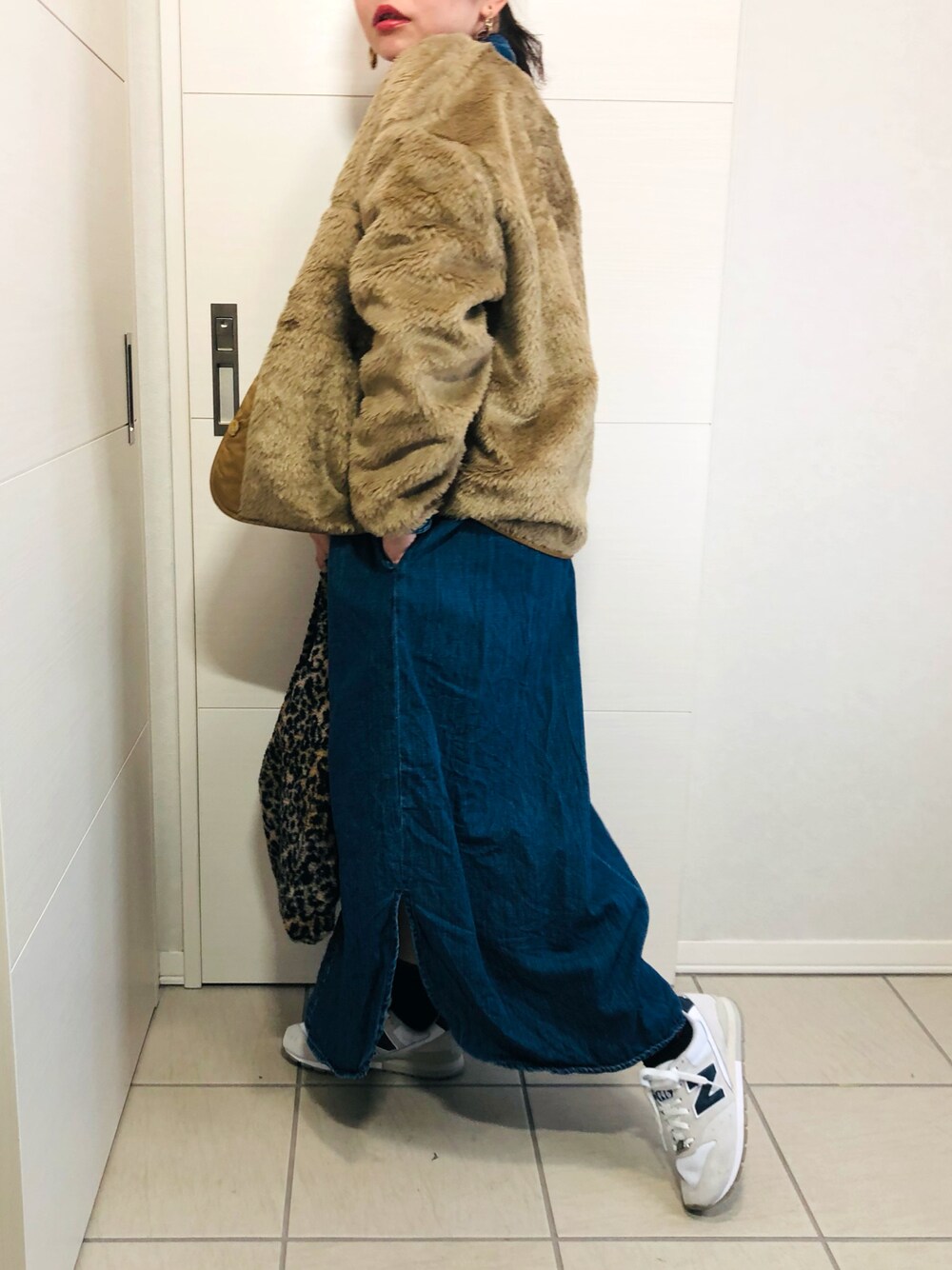 ベージュ系のブルゾン、ブルー系のワンピース、ホワイト系のスニーカーを着用したレディースの冬コーディネートの1枚目の写真