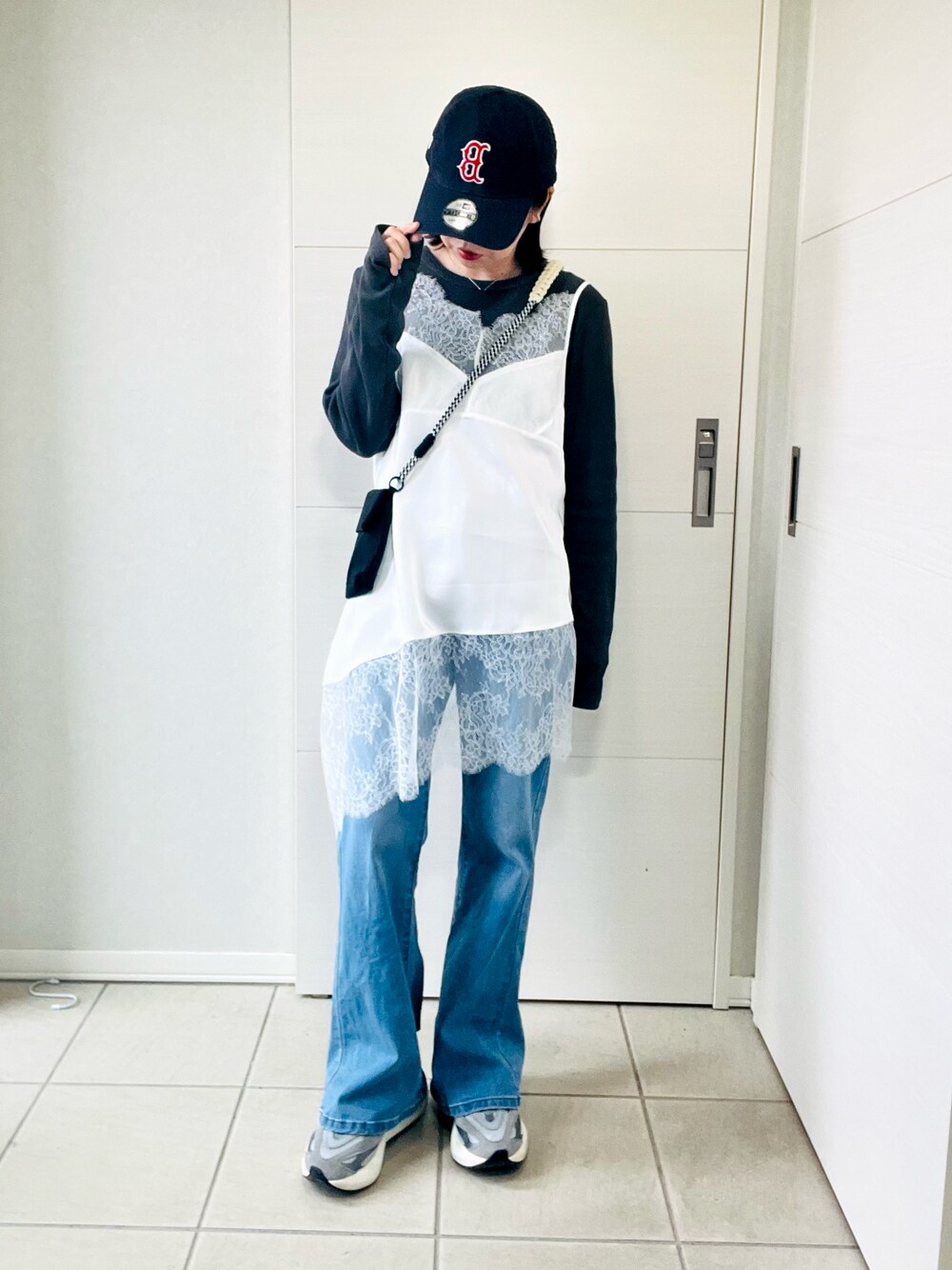 ホワイト系のキャミソール、グレー系のTシャツ/カットソー、ブルー系のデニムパンツを着用したレディースの春コーディネートの1枚目の写真