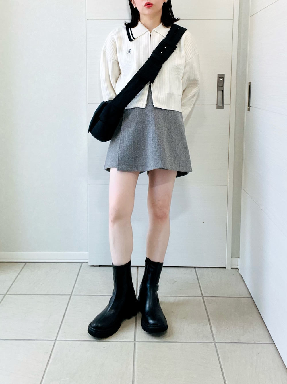 ホワイト系のニット/セーター、ブラック系のブーツ、グレー系のその他パンツを着用したレディースの秋コーディネートの1枚目の写真