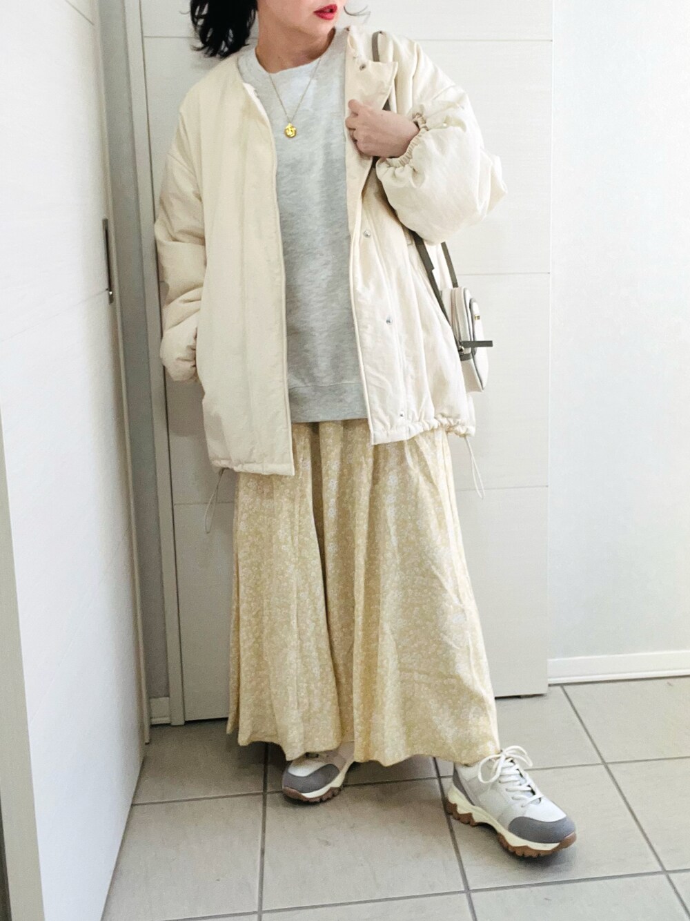 ホワイト系のブルゾン、グレー系のスウェット、イエロー系のスカートを着用したレディースの冬コーディネートの1枚目の写真