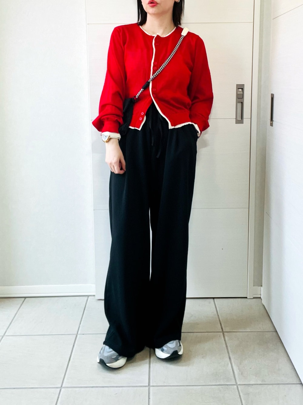 レッド系のカーディガン/ボレロ、ブラック系のその他パンツ、グレー系のスニーカーを着用したレディースの春コーディネートの1枚目の写真