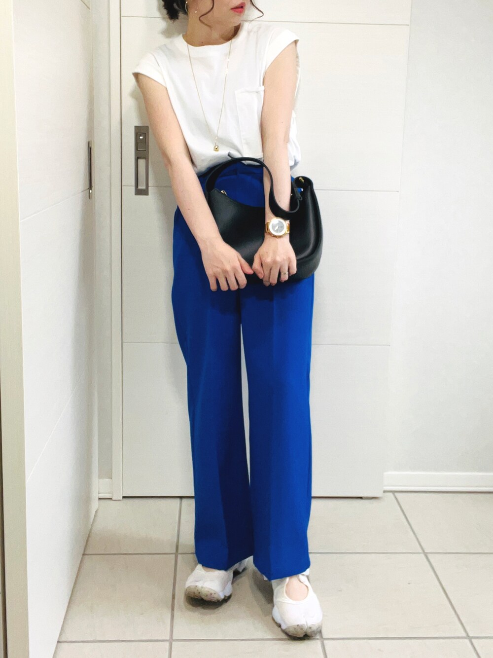 ホワイト系のTシャツ/カットソー、ブルー系のスラックス、ホワイト系のサンダルを着用したレディースの夏コーディネートの1枚目の写真