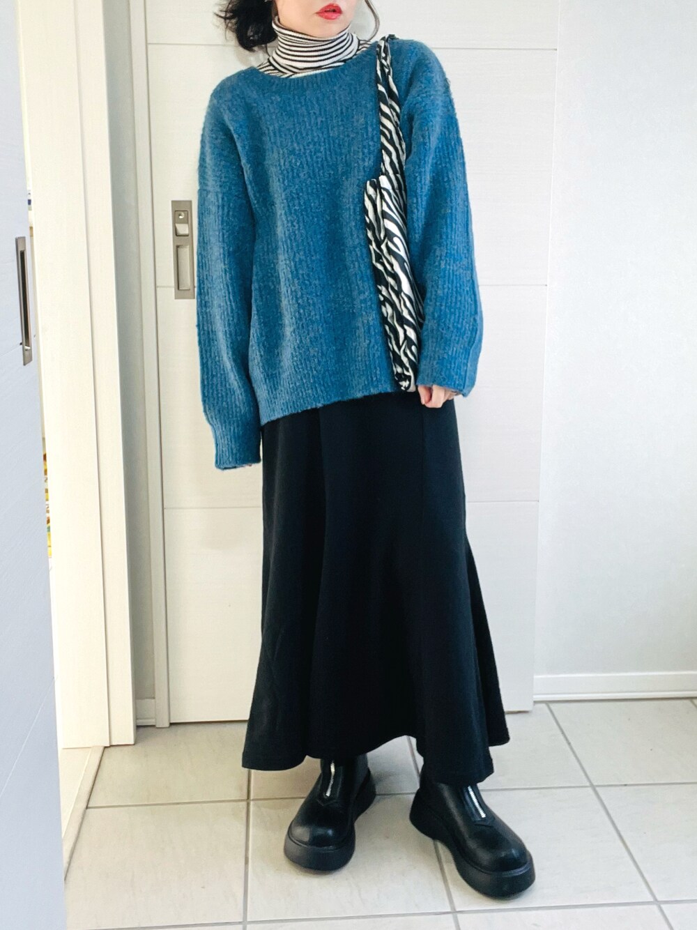 ブルー系のカーディガン/ボレロ、その他のニット/セーター、ブラック系のスカートを着用したレディースの秋コーディネートの1枚目の写真