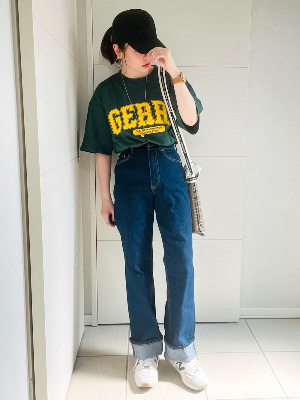 グリーン系のTシャツ/カットソー、ブルー系のデニムパンツ、ホワイト系のスニーカーを着用したレディースの夏コーディネートの1枚目の写真