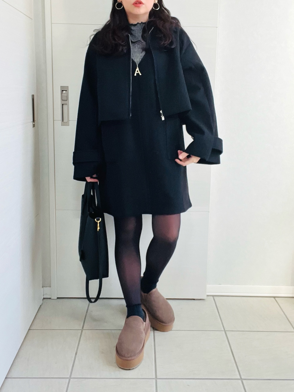 ブラック系のブルゾン、グレー系のTシャツ/カットソー、ブラック系のジャンパースカートを着用したレディースの冬コーディネートの1枚目の写真