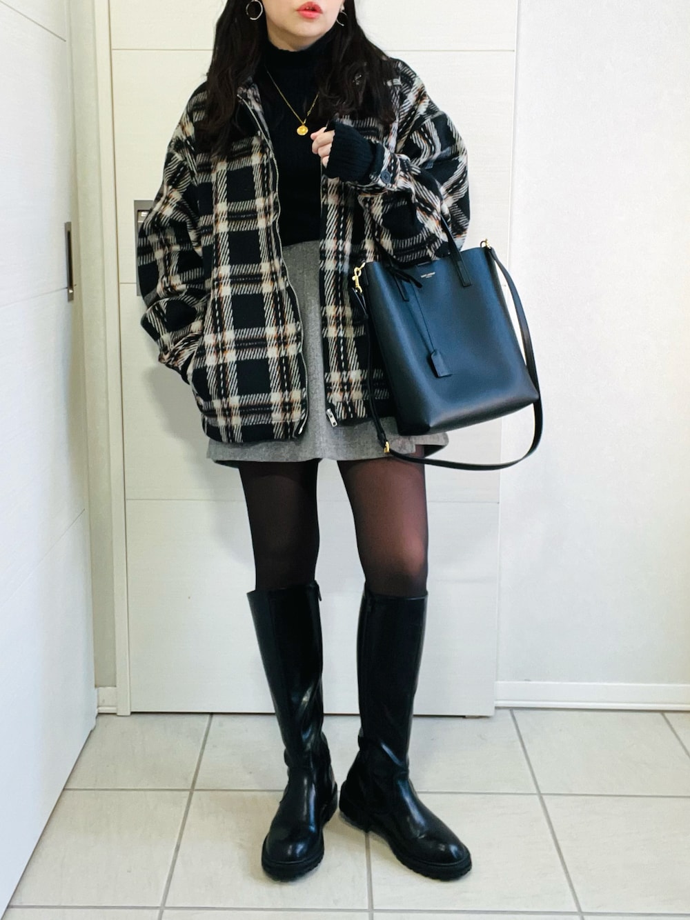 ブラック系のブルゾン、ブラック系のニット/セーター、グレー系のその他パンツを着用したレディースの冬コーディネートの1枚目の写真