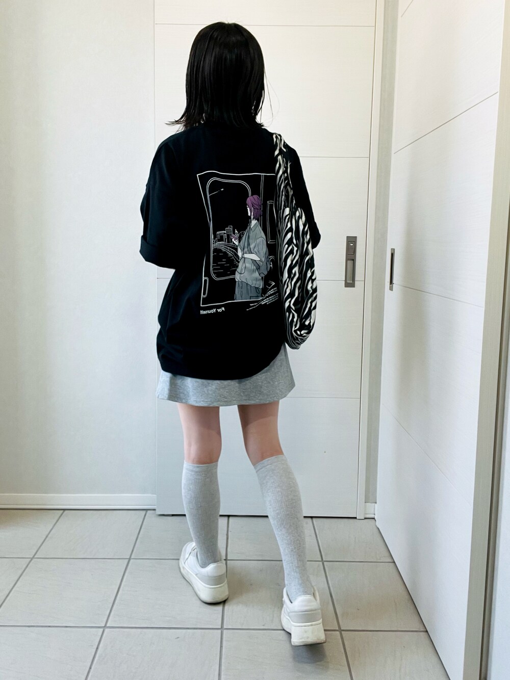 ブラック系のTシャツ/カットソー、ホワイト系のスニーカー、ブラック系のトートバッグを着用したレディースの春コーディネートの1枚目の写真