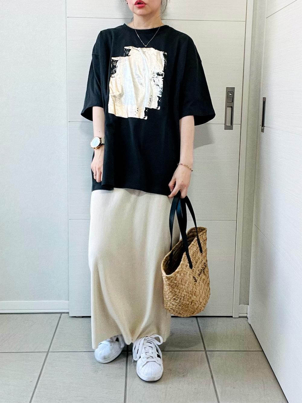 ブラック系のTシャツ/カットソー、ホワイト系のスカート、ホワイト系のスニーカーを着用したレディースの夏コーディネートの1枚目の写真