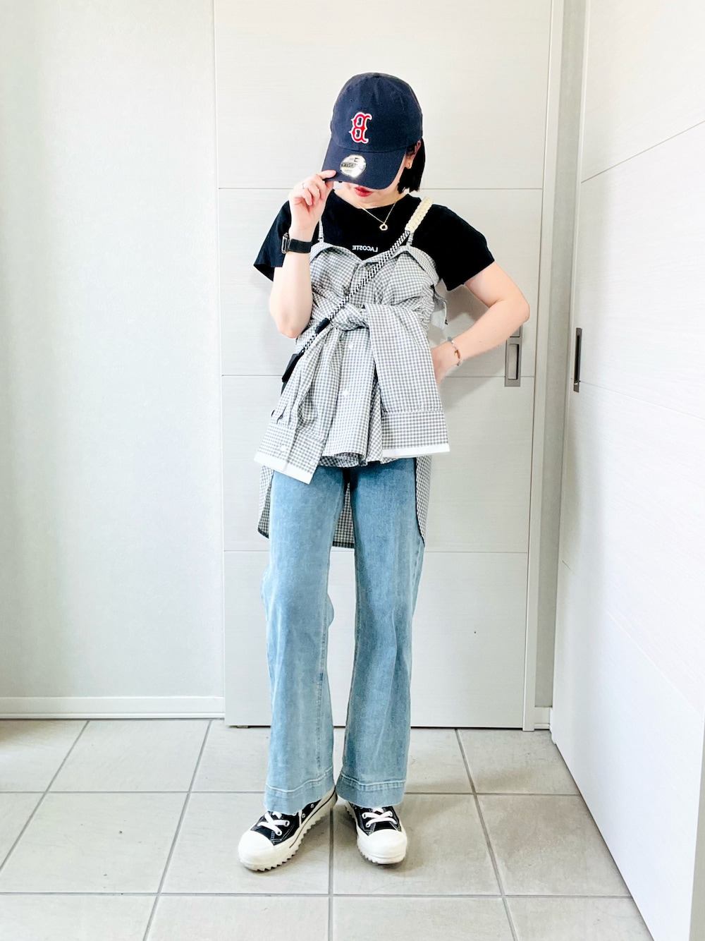 ホワイト系のシャツ/ブラウス、ブラック系のスニーカー、ブルー系のデニムパンツを着用したレディースの夏コーディネートの1枚目の写真