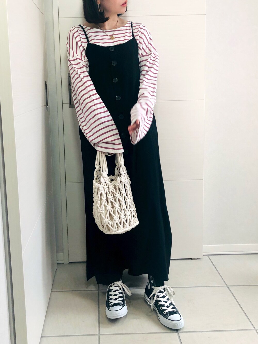 ピンク系のTシャツ/カットソー、ブラック系のワンピース、ブラック系のスニーカーを着用したレディースの夏コーディネートの1枚目の写真