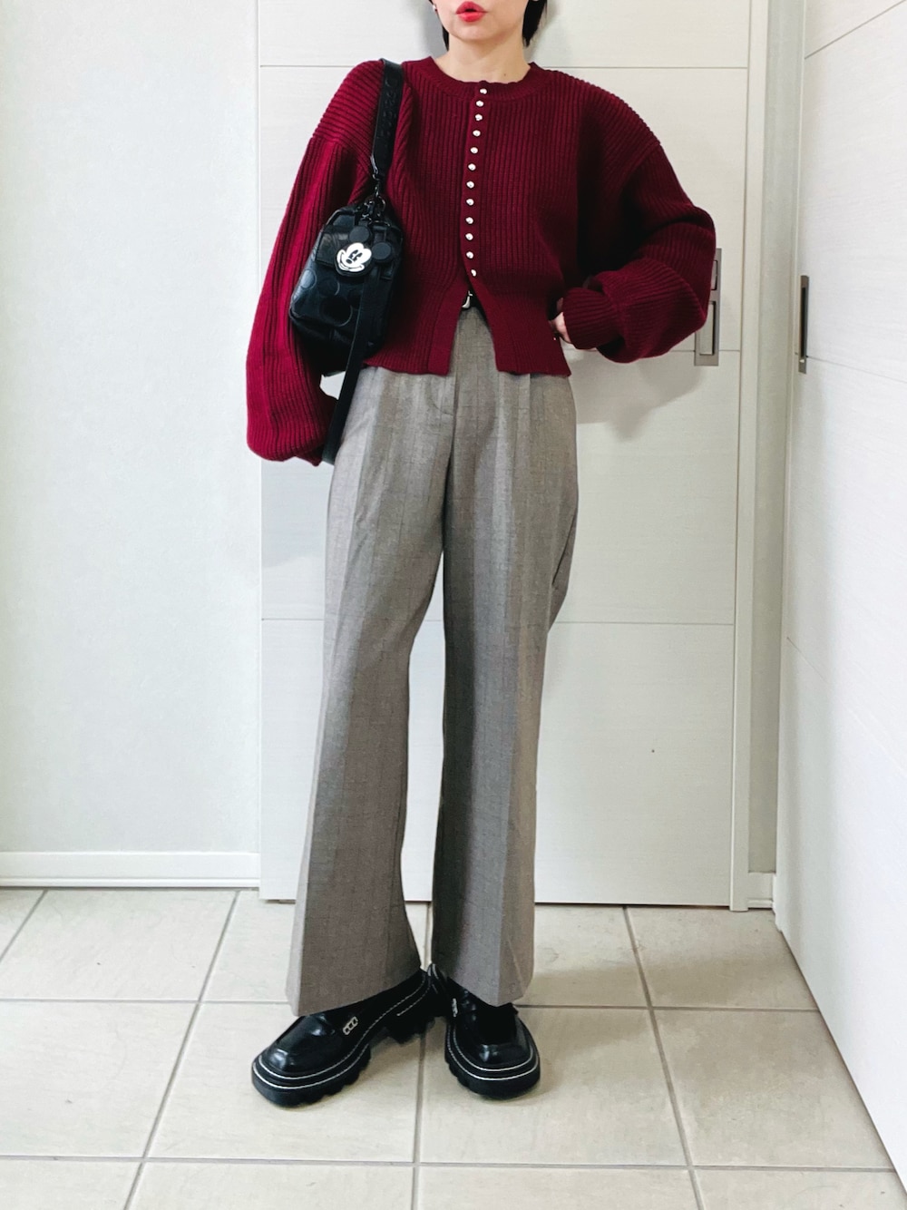 レッド系のカーディガン/ボレロ、その他のその他パンツ、ブラック系のハンドバッグを着用したレディースの秋コーディネートの1枚目の写真