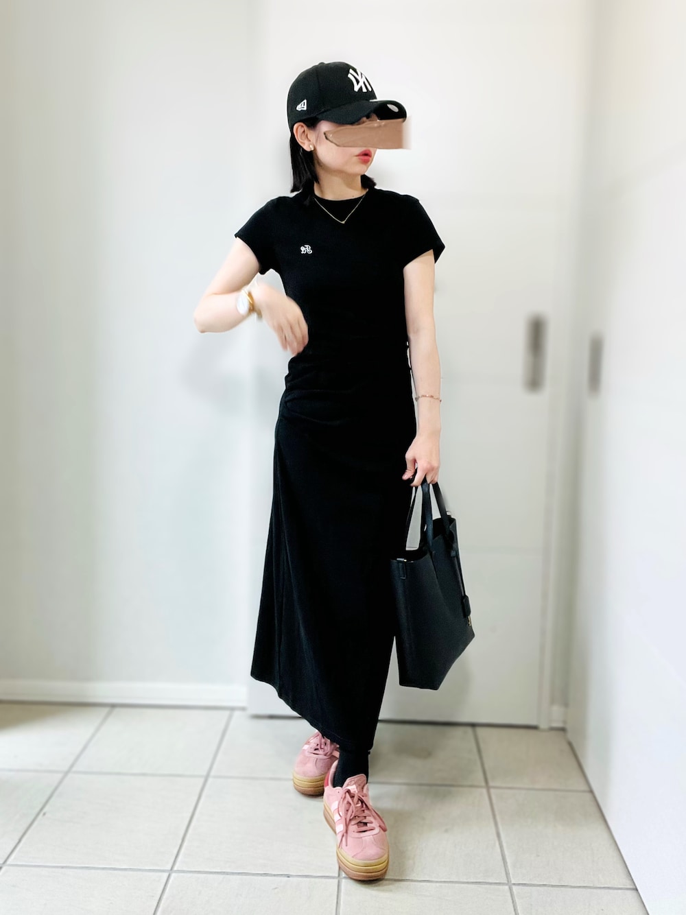 ブラック系のワンピース、レッド系のスニーカー、ブラック系のトートバッグを着用したレディースの夏コーディネートの1枚目の写真