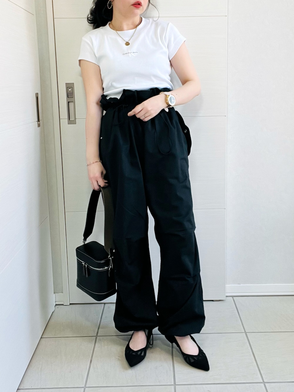 ホワイト系のTシャツ/カットソー、ブラック系のカーゴパンツ、ブラック系のパンプスを着用したレディースの春コーディネートの1枚目の写真