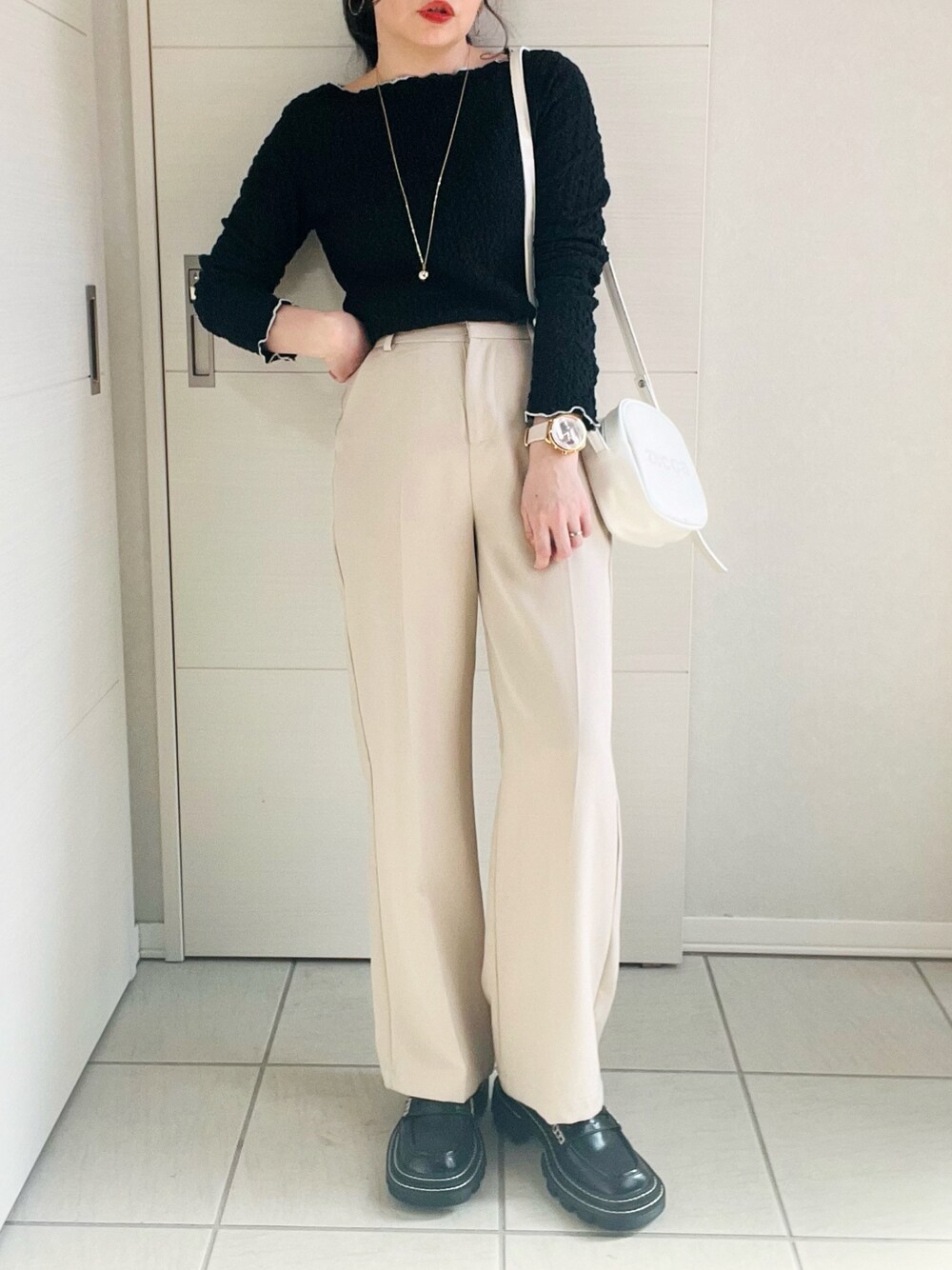 ブラック系のTシャツ/カットソー、ホワイト系のスラックス、ブラック系のローファーを着用したレディースの春コーディネートの1枚目の写真