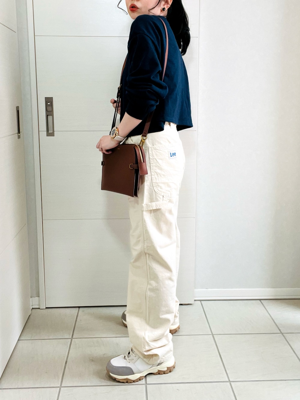 ホワイト系のデニムパンツ、ブルー系のカーディガン/ボレロ、ベージュ系のスニーカーを着用したレディースの春コーディネートの1枚目の写真