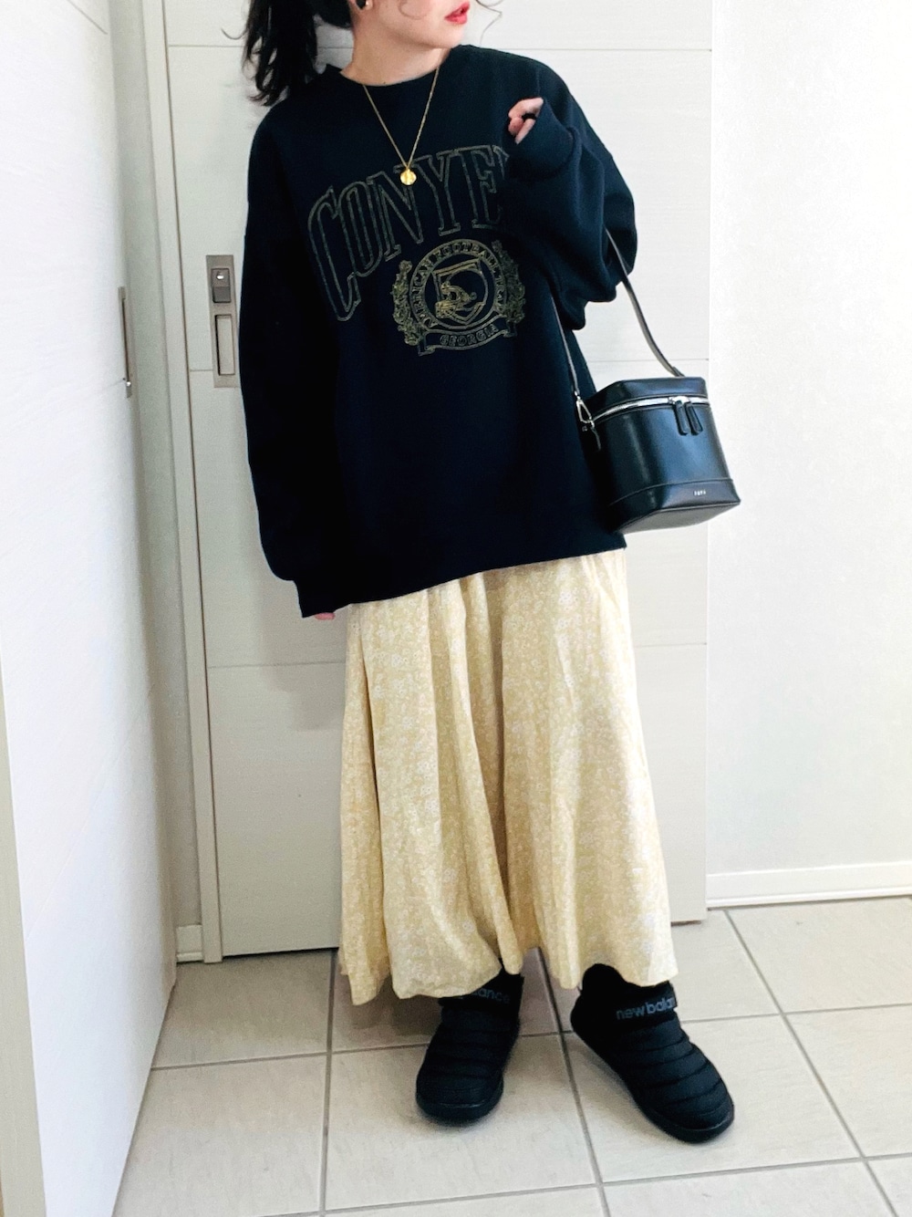 ブルー系のスウェット、イエロー系のスカート、ブラック系のスニーカーを着用したレディースの冬コーディネートの1枚目の写真