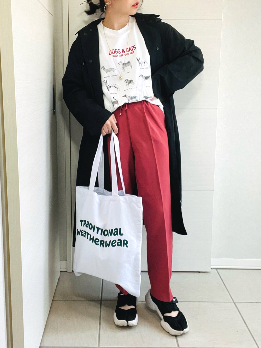 ホワイト系のTシャツ/カットソー、レッド系のスラックス、ブラック系のスニーカーを着用したレディースの春コーディネートの1枚目の写真