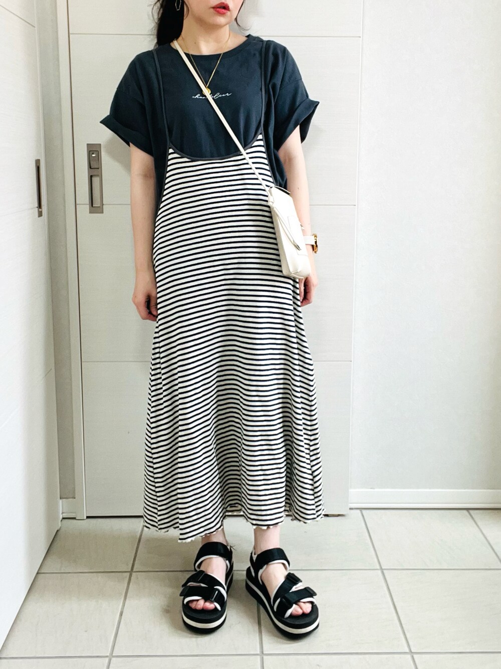 ブルー系のワンピース、グレー系のTシャツ/カットソー、ブラック系のサンダルを着用したレディースの夏コーディネートの1枚目の写真