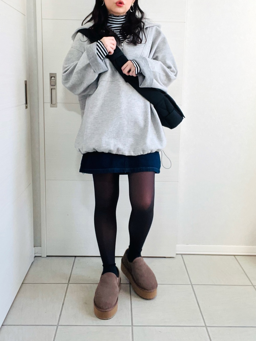 グレー系のパーカー、その他のTシャツ/カットソー、ブルー系のデニムスカートを着用したレディースの冬コーディネートの1枚目の写真