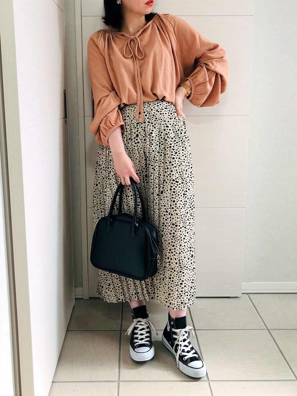 ピンク系のシャツ/ブラウス、ホワイト系のスカート、ブラック系のスニーカーを着用したレディースの夏コーディネートの1枚目の写真